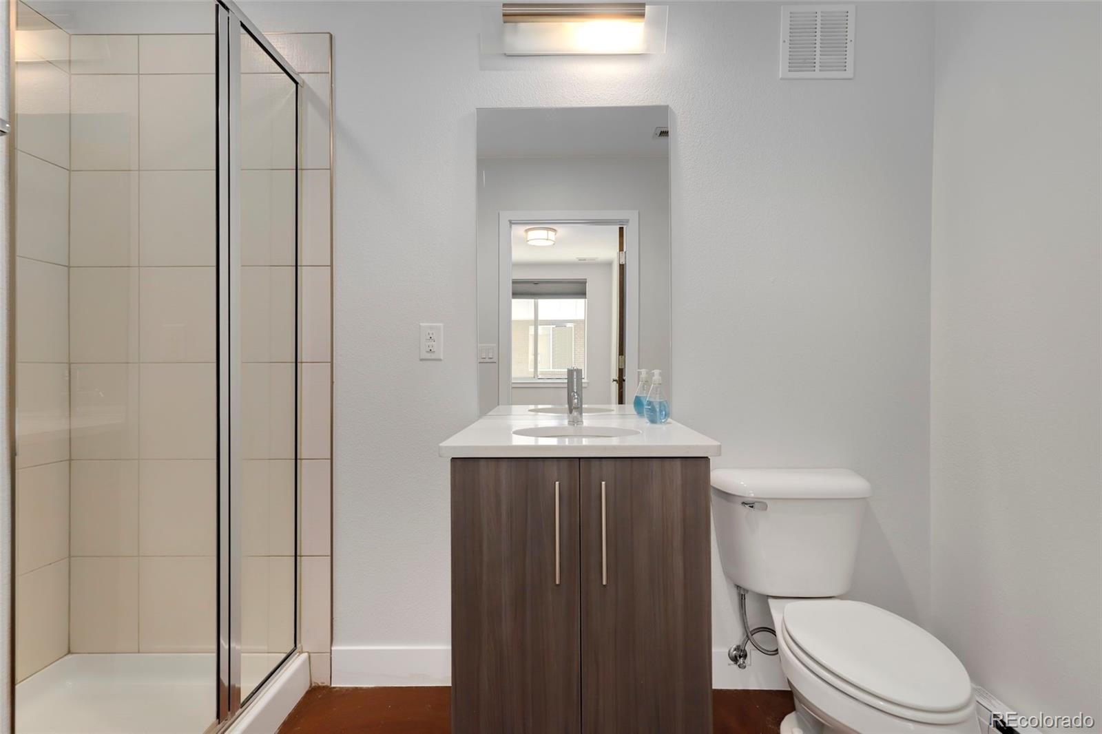 3336 Tejon Street, Unit 4 Denver, CO 80211 - Photo 18 of 35 a bathroom with a granite countertop toilet a sink and mirror