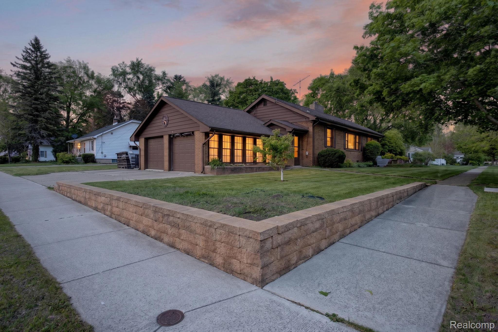 1209 Beatrice Street Flushing, MI 48433 - Photo 6 of 39 View of front of property featuring a lawn, concrete driveway, brick siding, a garage, and a chimney