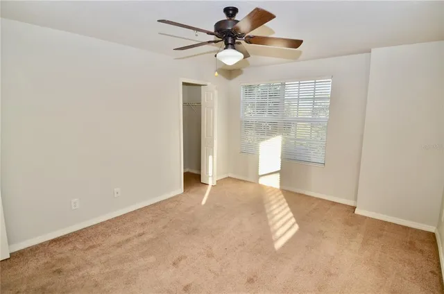 a view of a big room with windows and chandelier fan