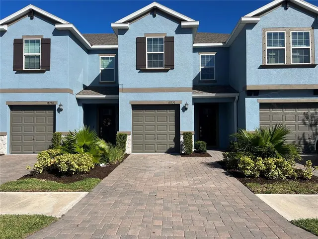 a front view of a house with a yard and outdoor seating