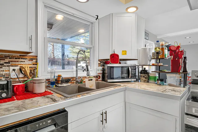 a kitchen with sink a stove and cabinets