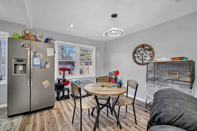 a view of a dining room with furniture a chandelier and wooden floor