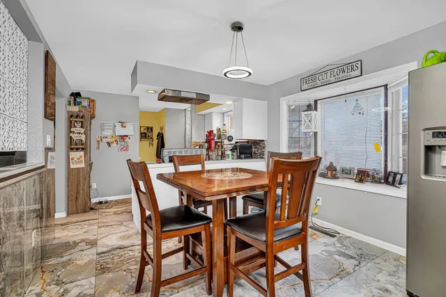 a view of a dining room and livingroom with furniture wooden floor a chandelier