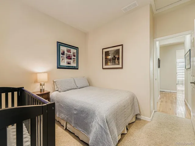 a bedroom with a bed and a painting on the wall