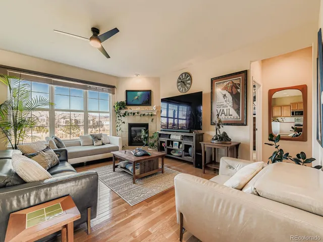 a living room with furniture fireplace and a large window