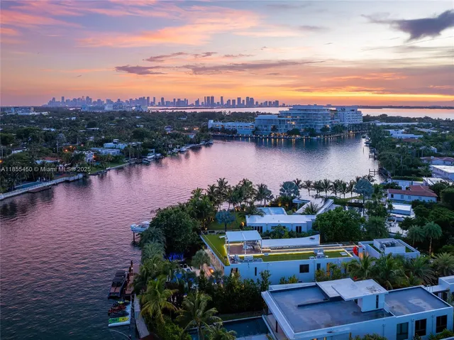 a kitchen with a sink stainless steel appliances and wooden floor