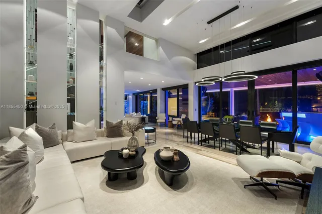 a living room with stainless steel appliances kitchen island granite countertop a refrigerator and a wooden cabinets