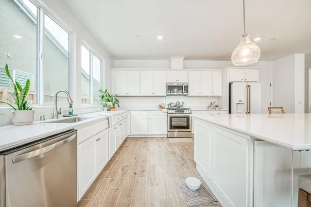 a kitchen with cabinets a sink and appliances