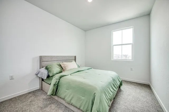 a bed sitting in a bedroom next to a window