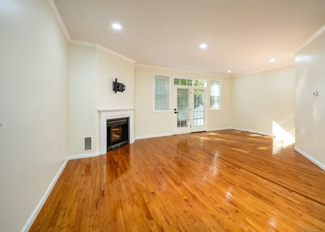 a view of empty room with wooden floor and fireplace
