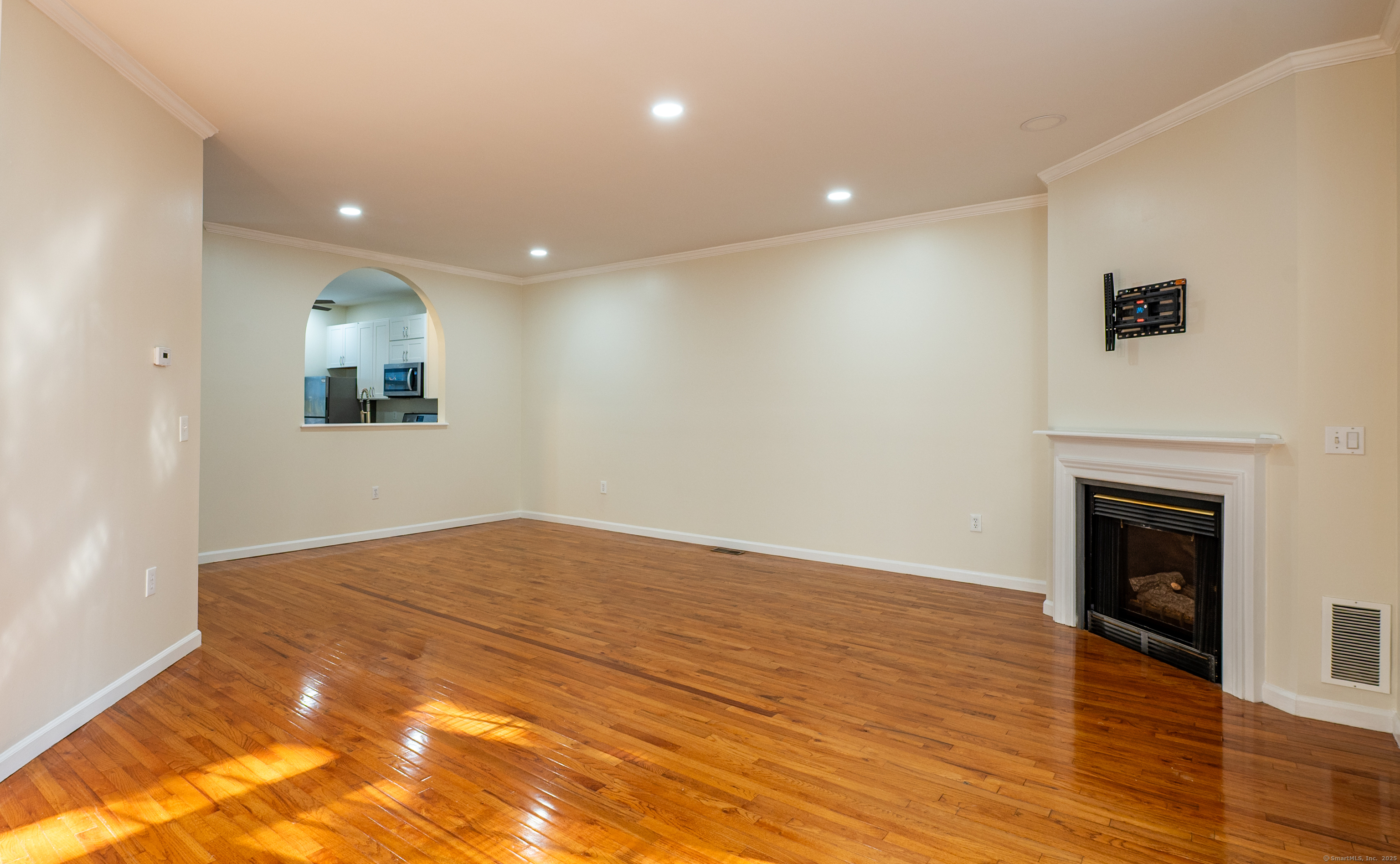 1 Munson Drive, Unit 3 Wallingford, CT 06492 - Photo 13 of 38 a view of empty room with wooden floor and fireplace