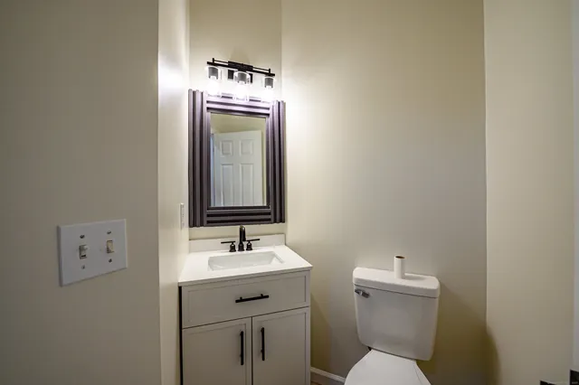 a bathroom with a toilet sink and mirror
