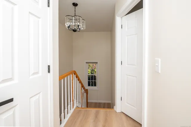 a view of a hallway with wooden floor and staircase