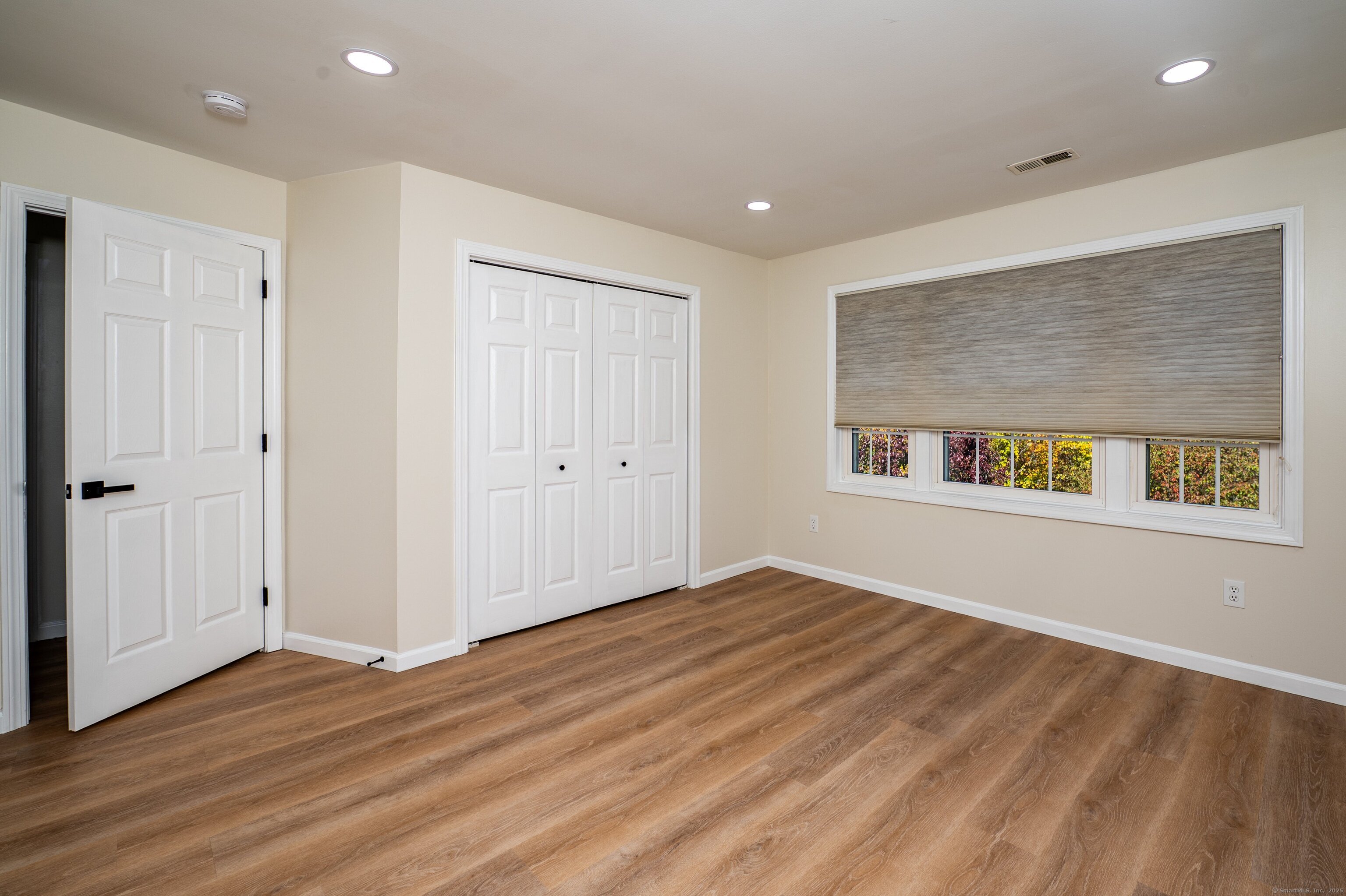1 Munson Drive, Unit 3 Wallingford, CT 06492 - Photo 21 of 38 a view of an empty room with wooden floor and a window