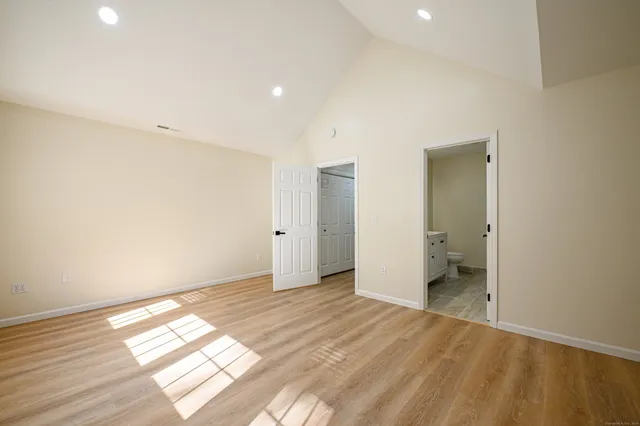 a view of empty room with wooden floor