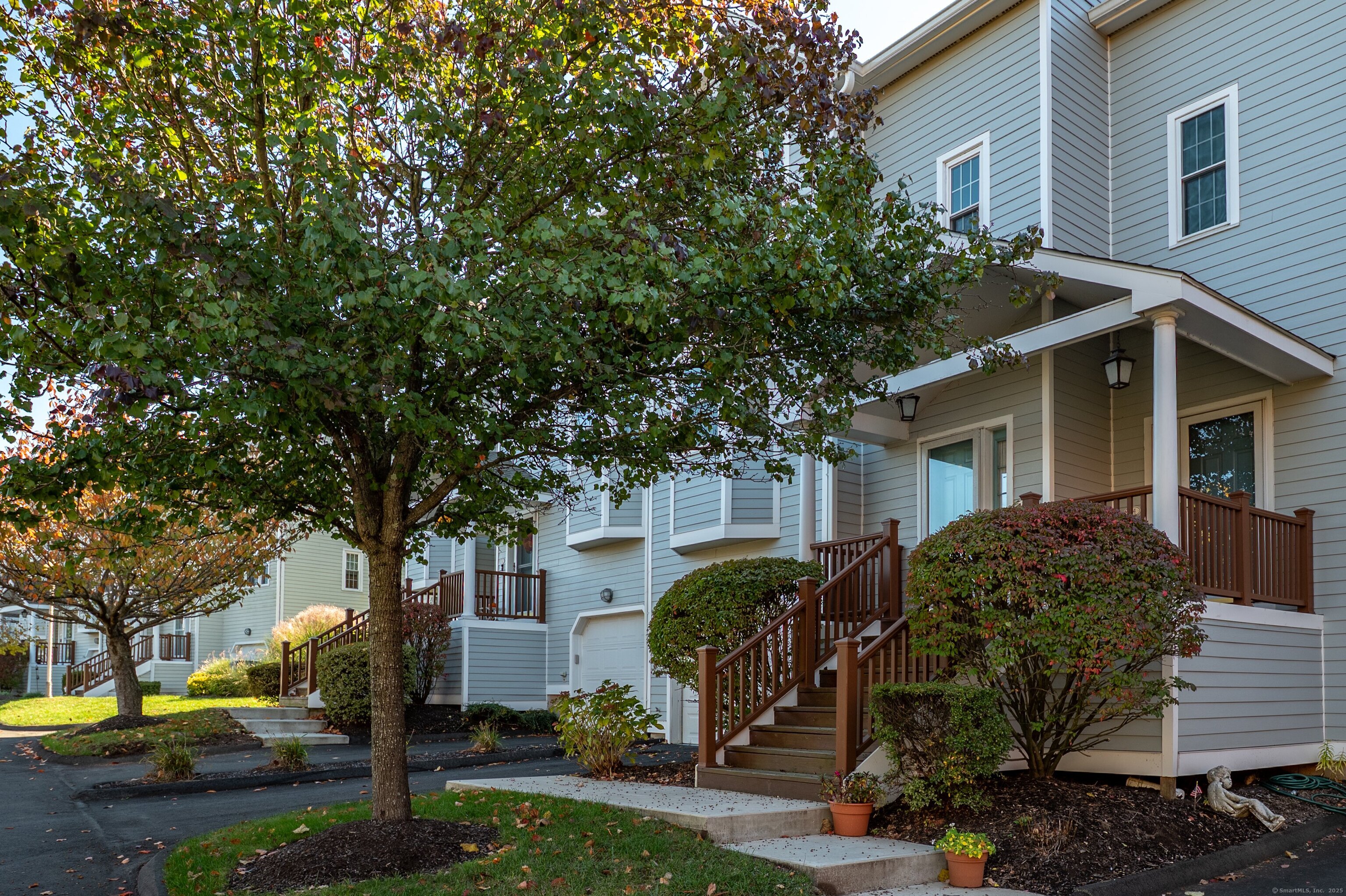 1 Munson Drive, Unit 3 Wallingford, CT 06492 - Photo 5 of 38 a view of a white house next to a yard with big trees