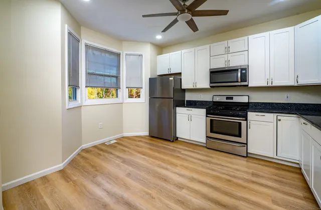 a kitchen with a refrigerator stove and white cabinets