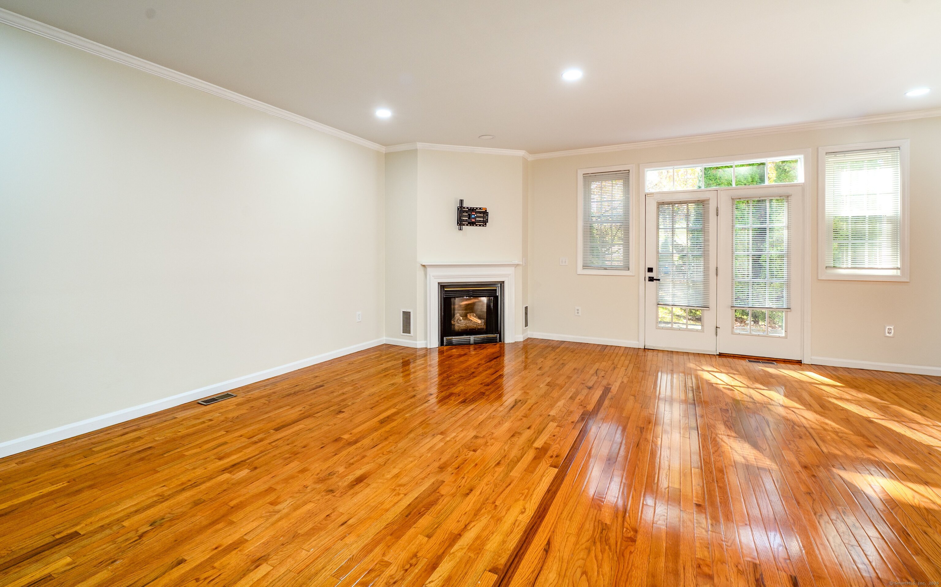 1 Munson Drive, Unit 3 Wallingford, CT 06492 - Photo 10 of 38 a view of empty room with wooden floor and fireplace