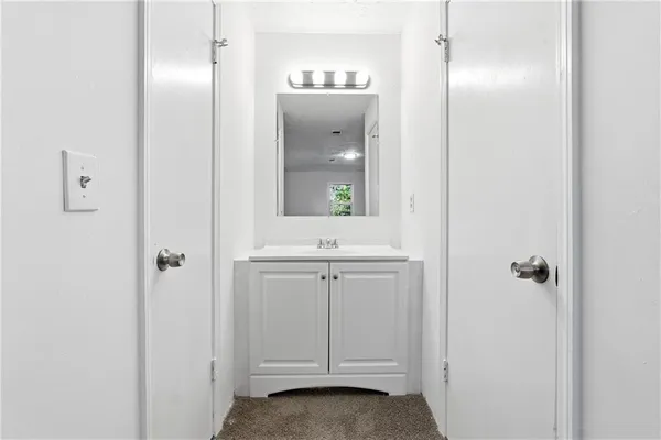 a bathroom with a sink a light fixture and a mirror