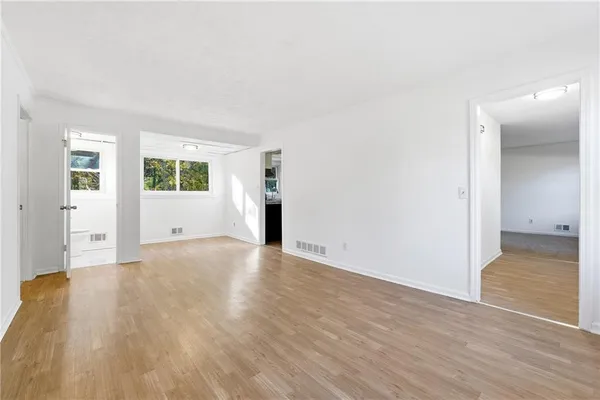 a view of empty room with wooden floor