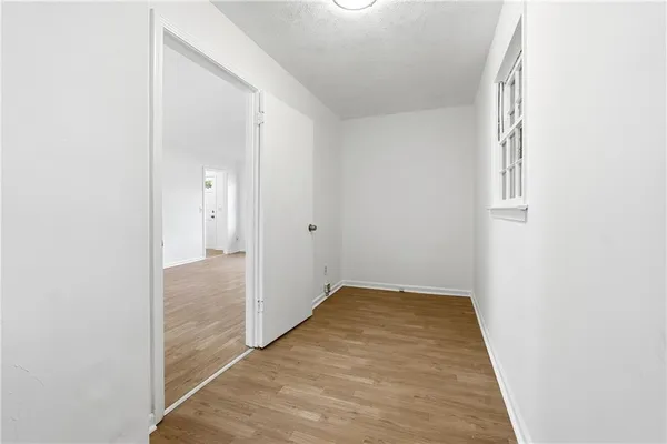 an empty room with wooden floor and mirror