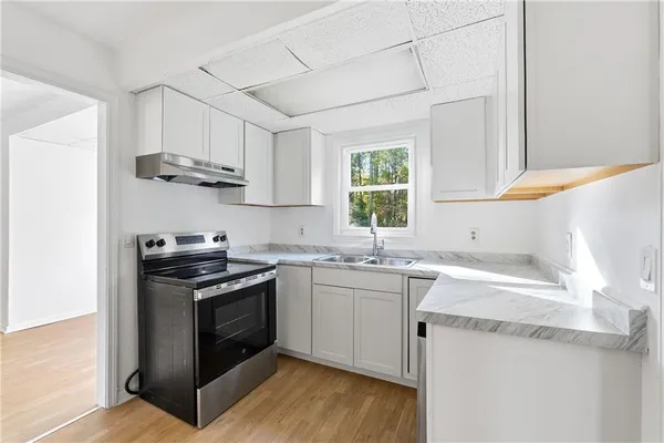 a kitchen with stainless steel appliances granite countertop a sink stove a sink dishwasher and cabinets with wooden floor