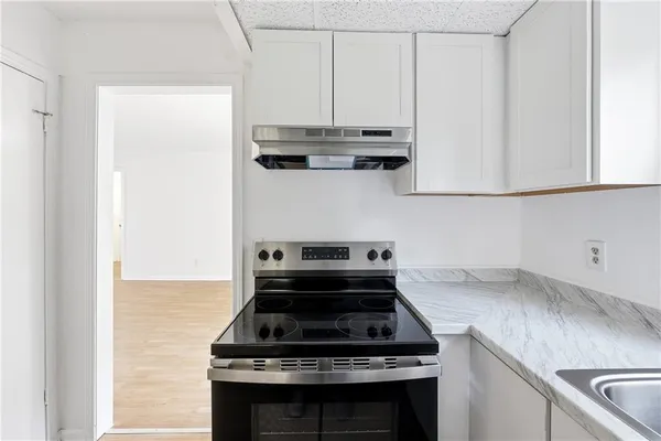 a stove top oven sitting inside of a kitchen