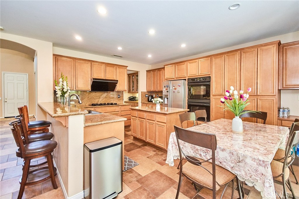 12430 Split Rein Drive Rancho Cucamonga, CA 91739 - Photo 24 of 29 a kitchen with a refrigerator and a stove top oven