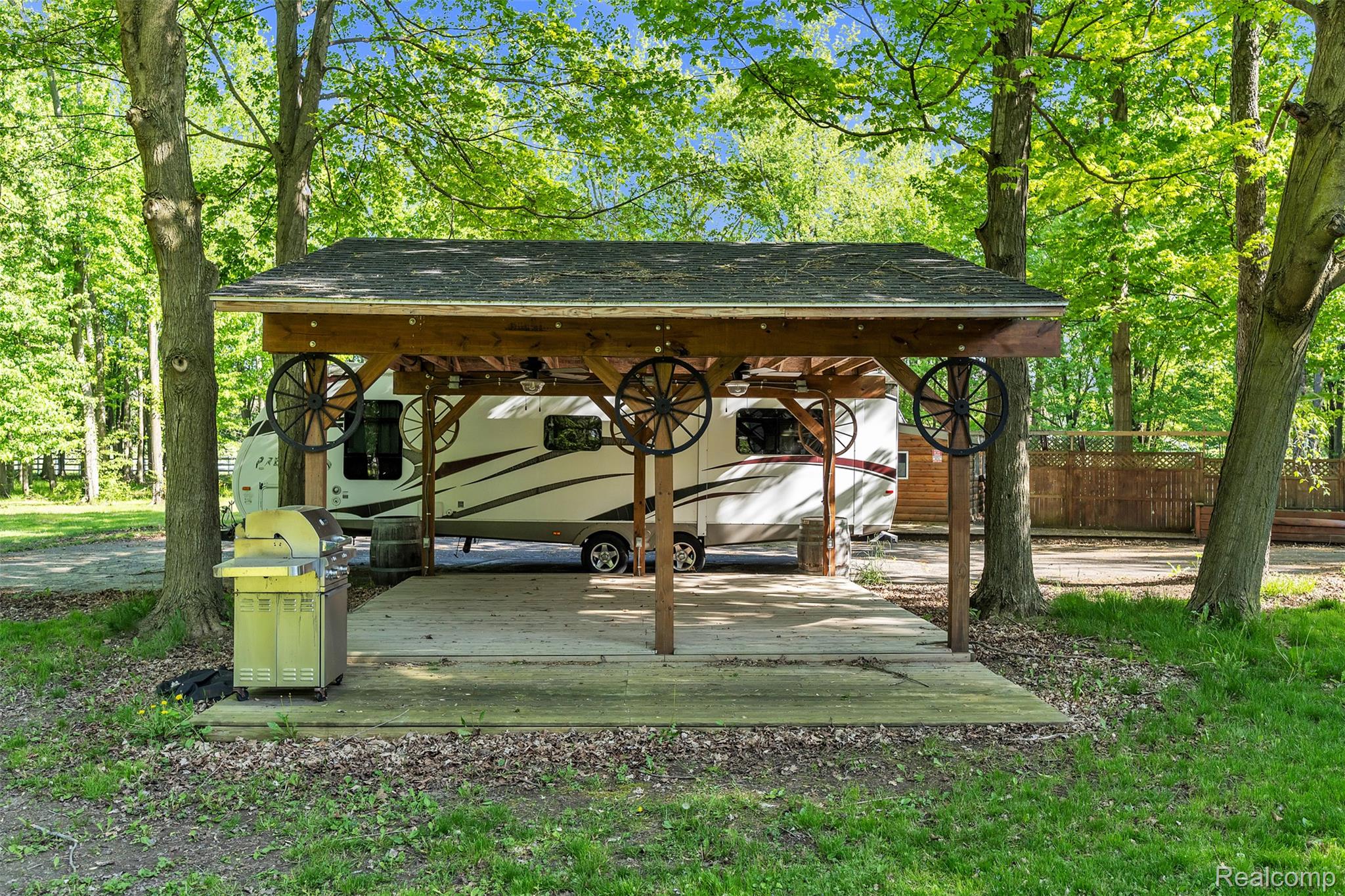 1345 Ives Road Mason, MI 48854 - Photo 67 of 92 View of patio featuring area for grilling, a carport, and view of scattered trees