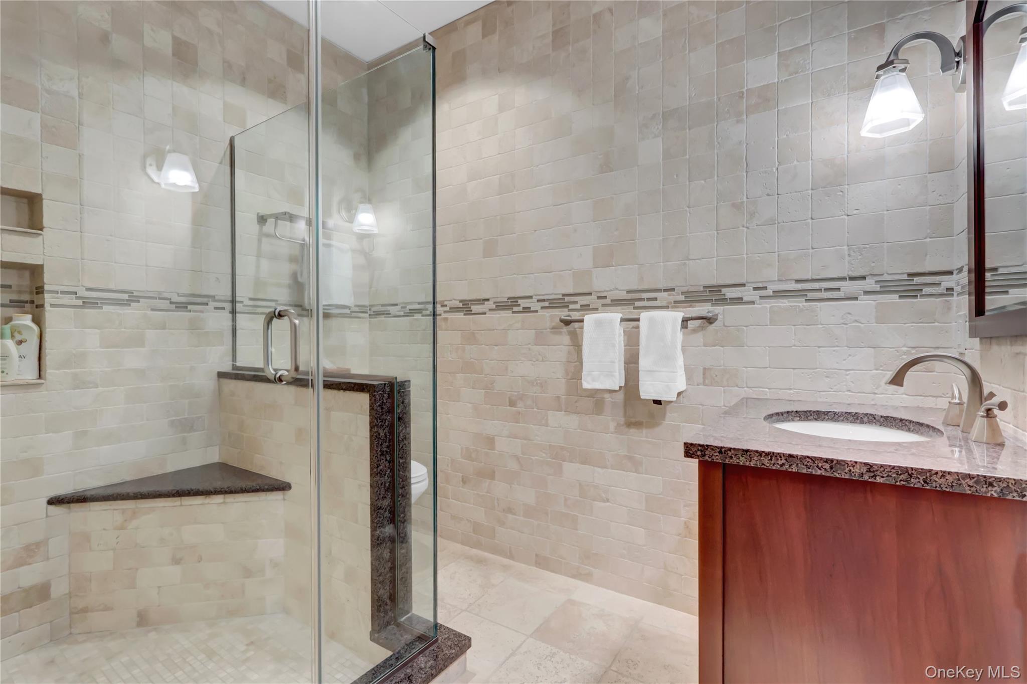 63 Dyke Road Setauket, NY 11733 - Photo 14 of 49 Full bath featuring tile walls, vanity, a stall shower, and light tile patterned floors
