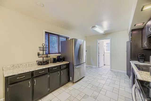 a kitchen with stainless steel appliances granite countertop a refrigerator and a sink