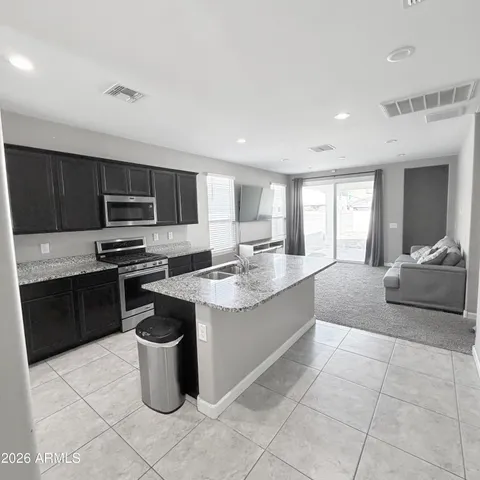 a kitchen with a sink a stove top oven and cabinets