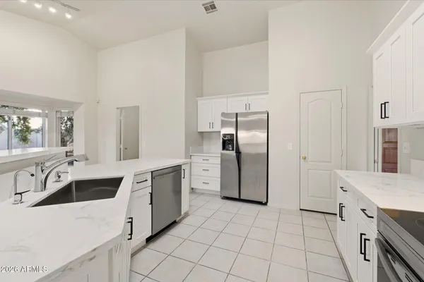 a large kitchen with a stove a refrigerator and a sink