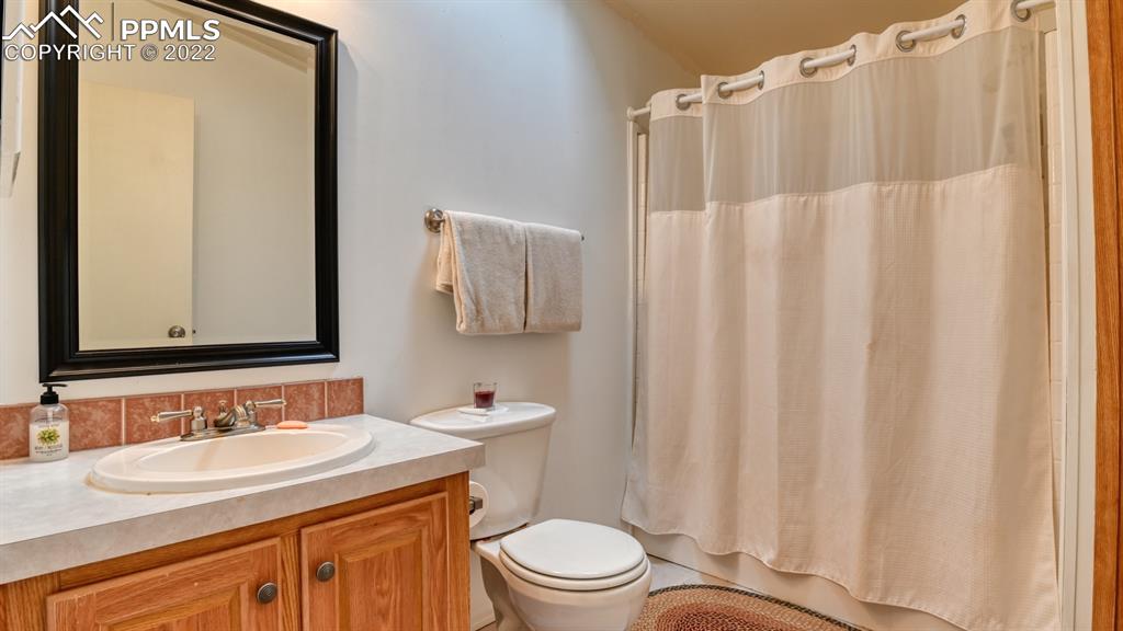 34475 East Jones Road Yoder, CO 80864 - Photo 21 of 37 a bathroom with a sink a toilet and shower curtain