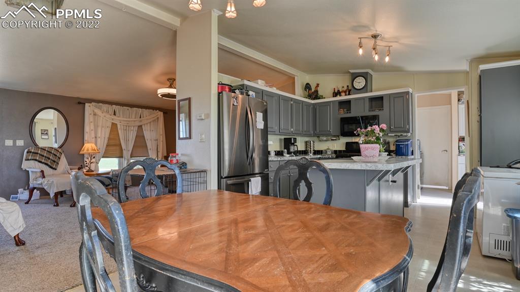 34475 East Jones Road Yoder, CO 80864 - Photo 8 of 37 a kitchen with stainless steel appliances kitchen island granite countertop a dining table and chairs