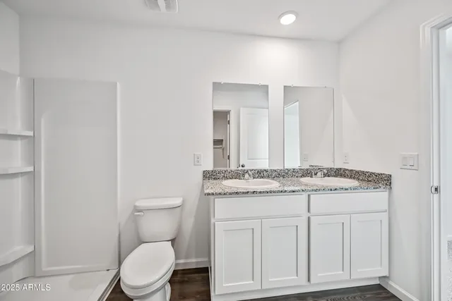 a bathroom with a granite countertop toilet sink and mirror