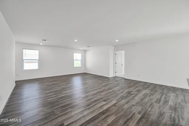 an empty room with wooden floor and window