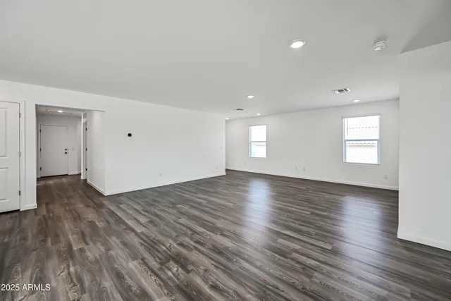 a view of empty room with window and wooden floor