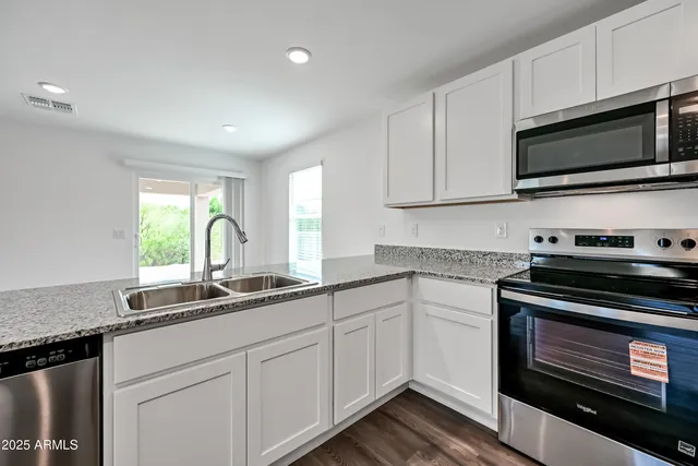 a kitchen with stainless steel appliances a stove microwave and sink