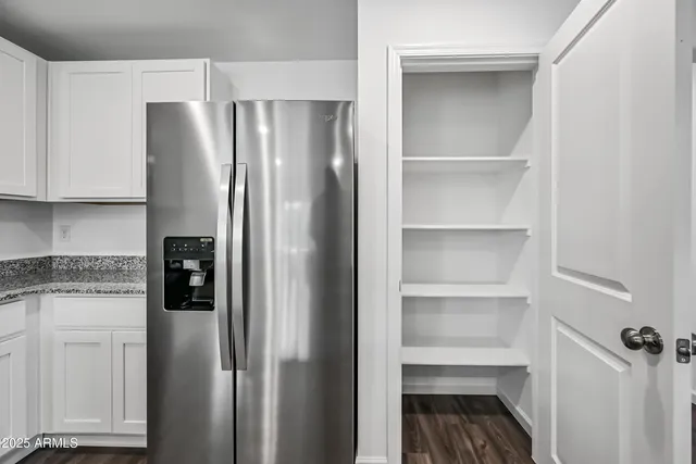 a kitchen with a refrigerator and cabinets