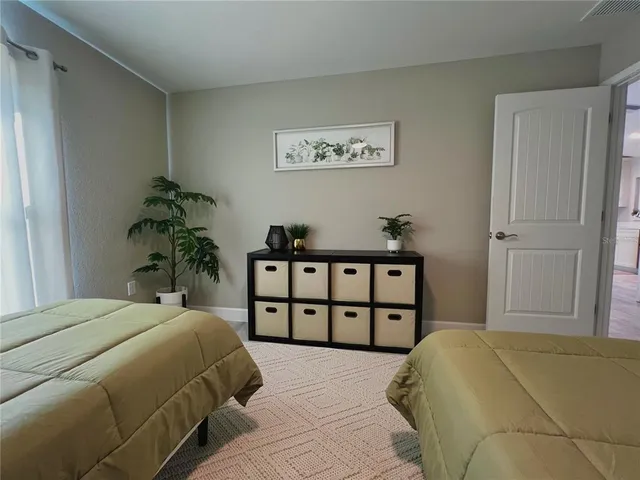 a bedroom with a bed and a potted plant