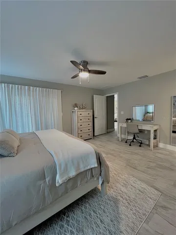 a spacious bedroom with a bed and a chandelier