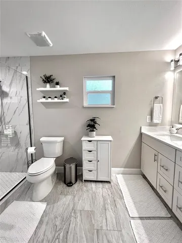 a spacious bathroom with a toilet sink and mirror