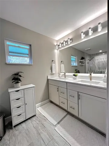 a spacious bathroom with a double vanity sink a mirror a and a