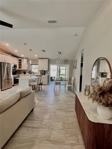 a living room with furniture and a view of kitchen