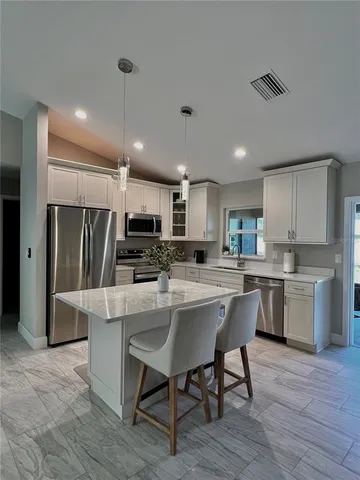 a kitchen with kitchen island wooden cabinets and stainless steel appliances