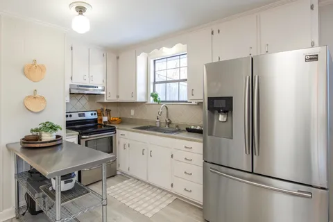 a kitchen with stainless steel appliances granite countertop a refrigerator sink and stove