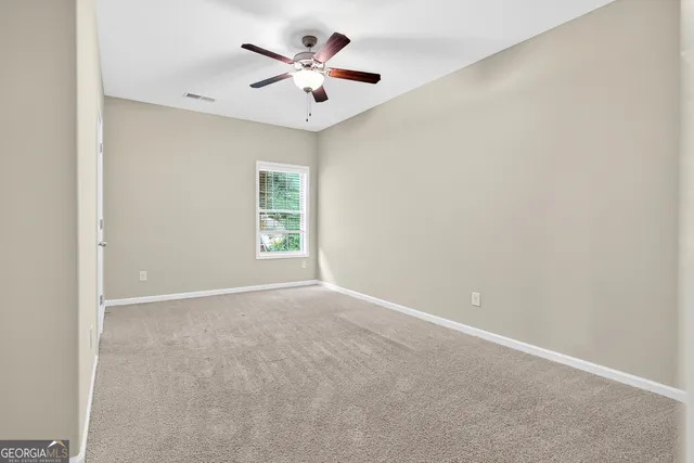 an empty room with a window and a ceiling fan