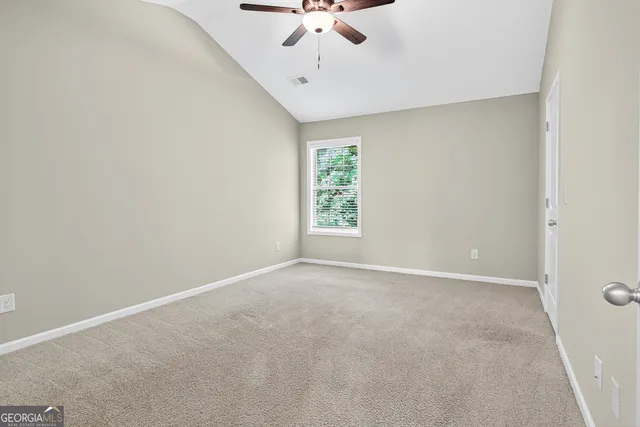 an empty room with a window and a ceiling fan