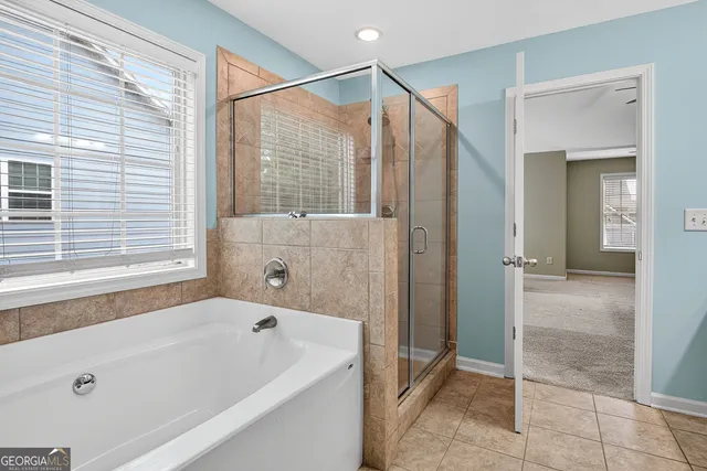 a bathroom with a tub a sink and a glass door shower